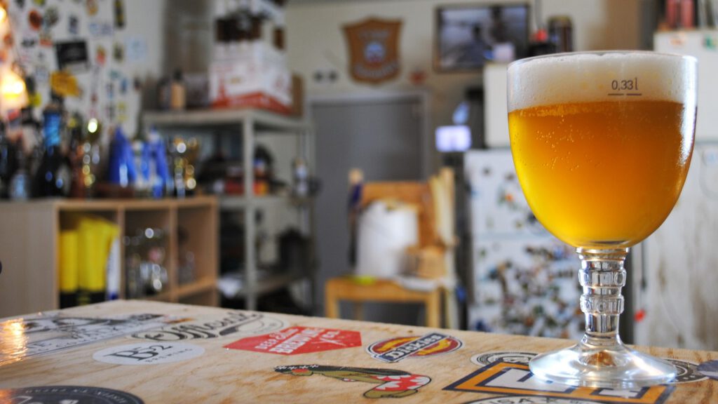 Un assortiment de bières belges de différents styles et saveurs, y compris des blondes, des ambrées, des brunes et des noires, ainsi que des bières de Noël, des bières d'abbaye et des lambics